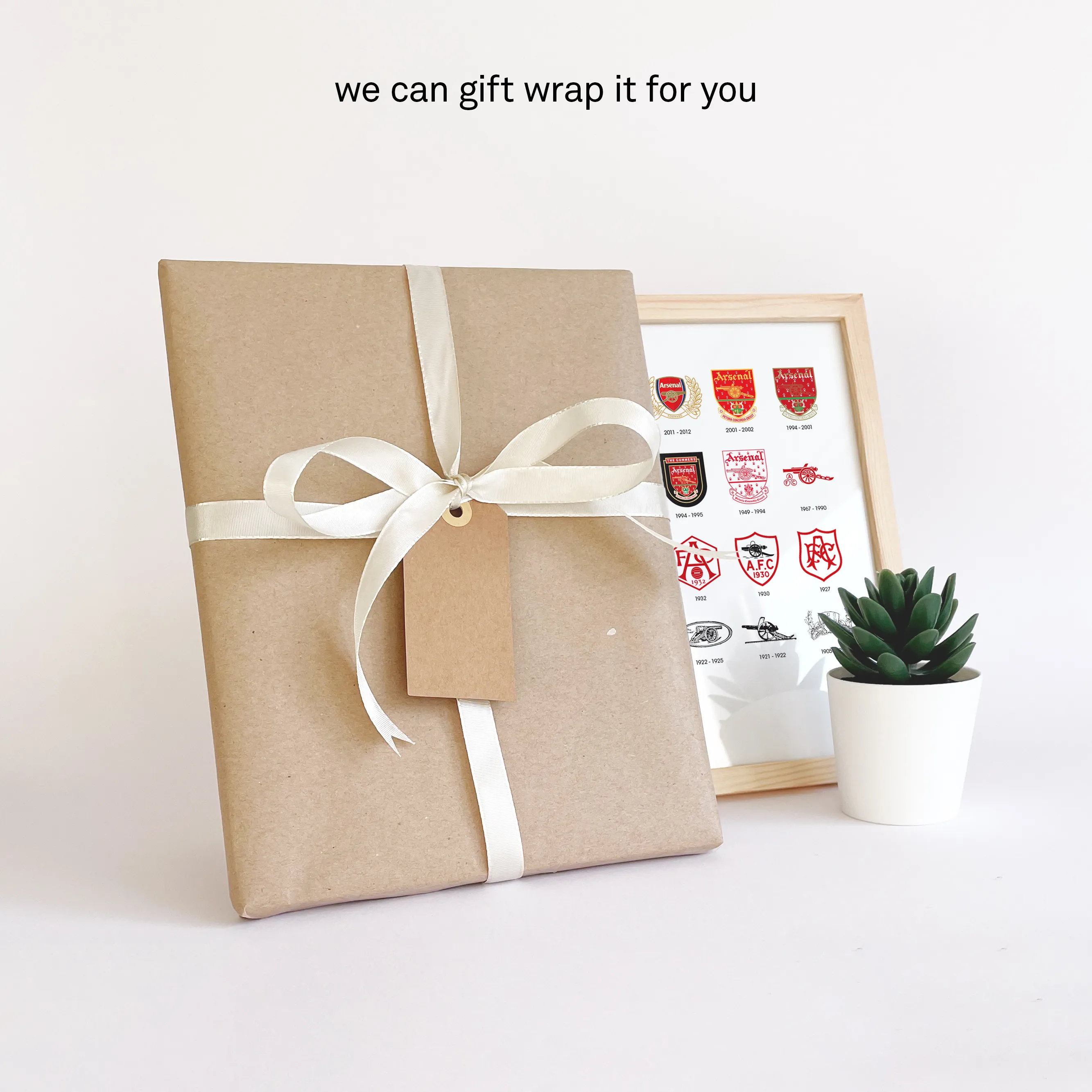Arsenal badge history print gift-wrapped in brown paper with white ribbon and personal note card