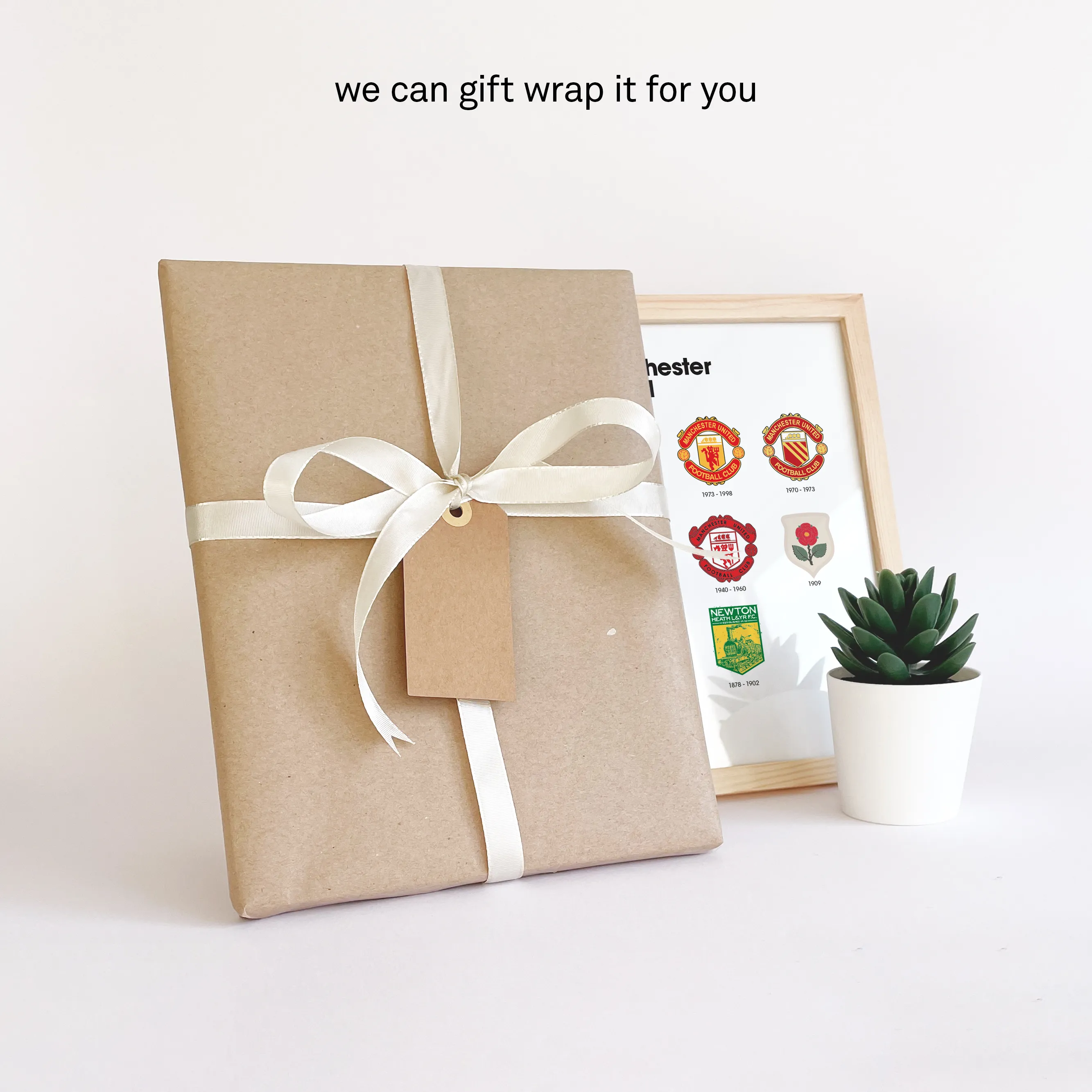 Manchester United logo history print gift-wrapped in brown paper with white ribbon and a personal note card