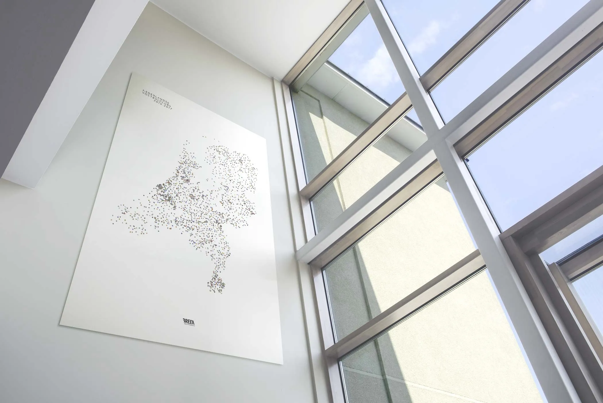 Nederlandse voetbalclubs poster bij raam in moderne woonkamer—KNVB-partner voetbal kunst
